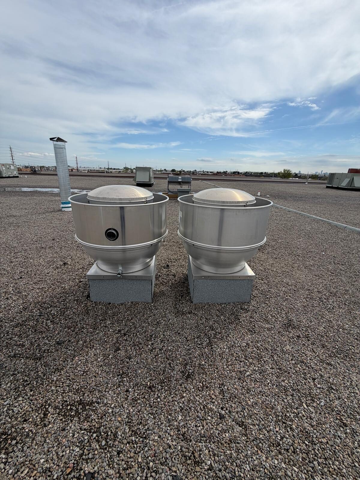 Two upblast exhaust fans installed on a flat roof