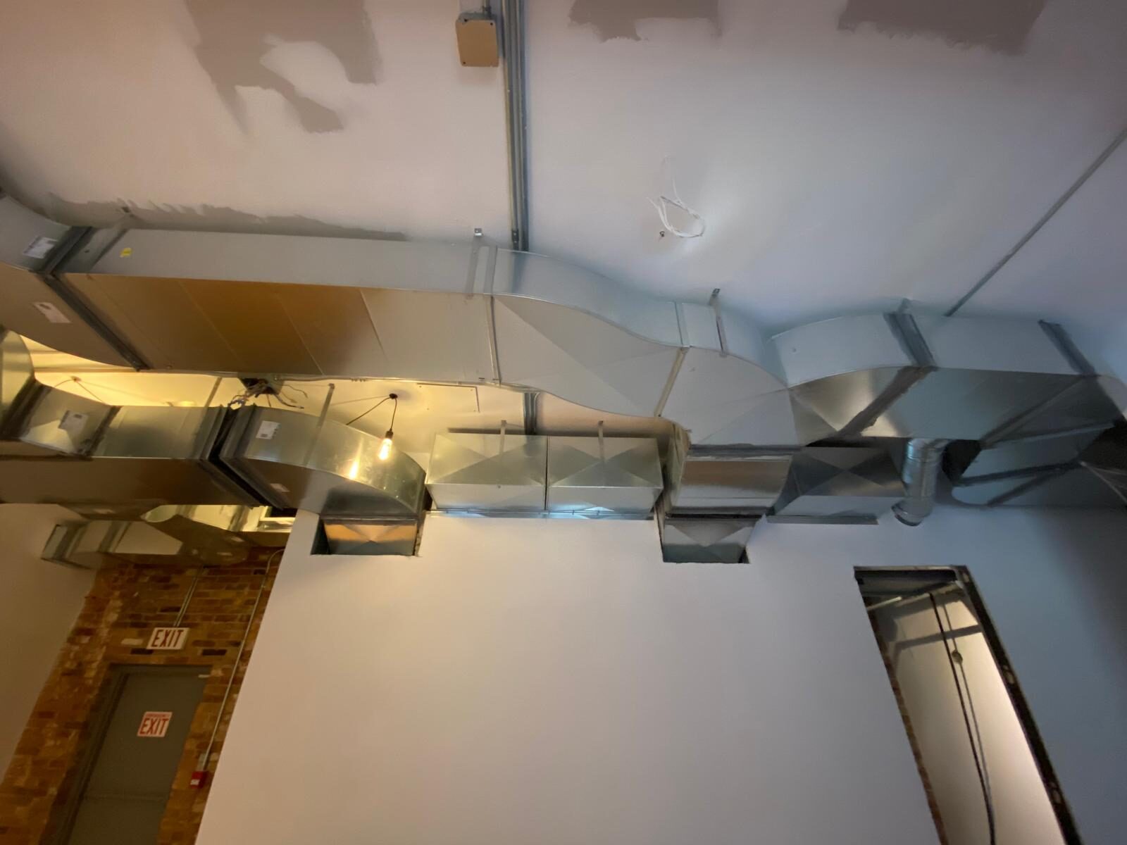 Exposed rectangular ductwork running across a commercial ceiling