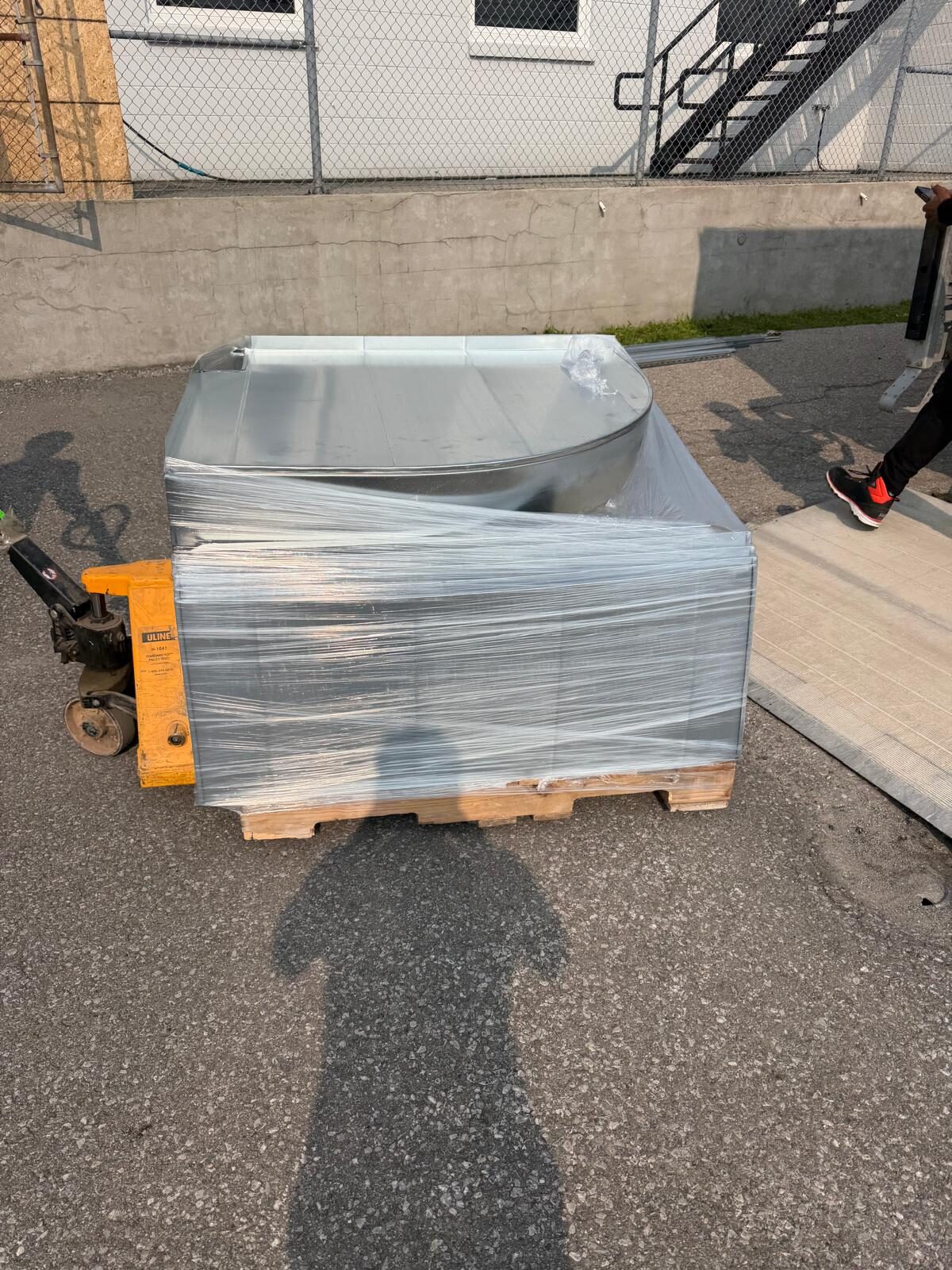 A shrink-wrapped sheet metal assembly on a pallet, ready for delivery